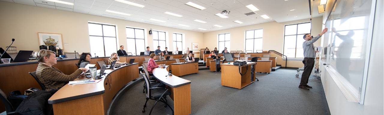Panorama of Seidman Executive MBA students learning from their instructor in class.